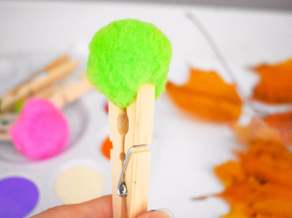 Clothespin holding lime green pom pom