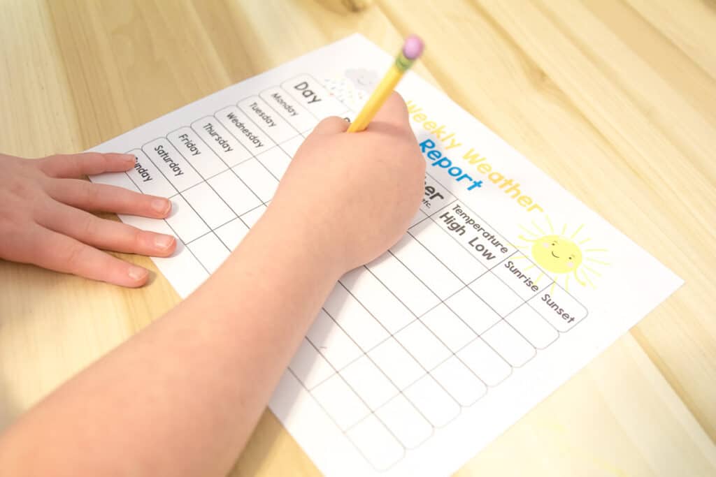 Child filling out a weather chart