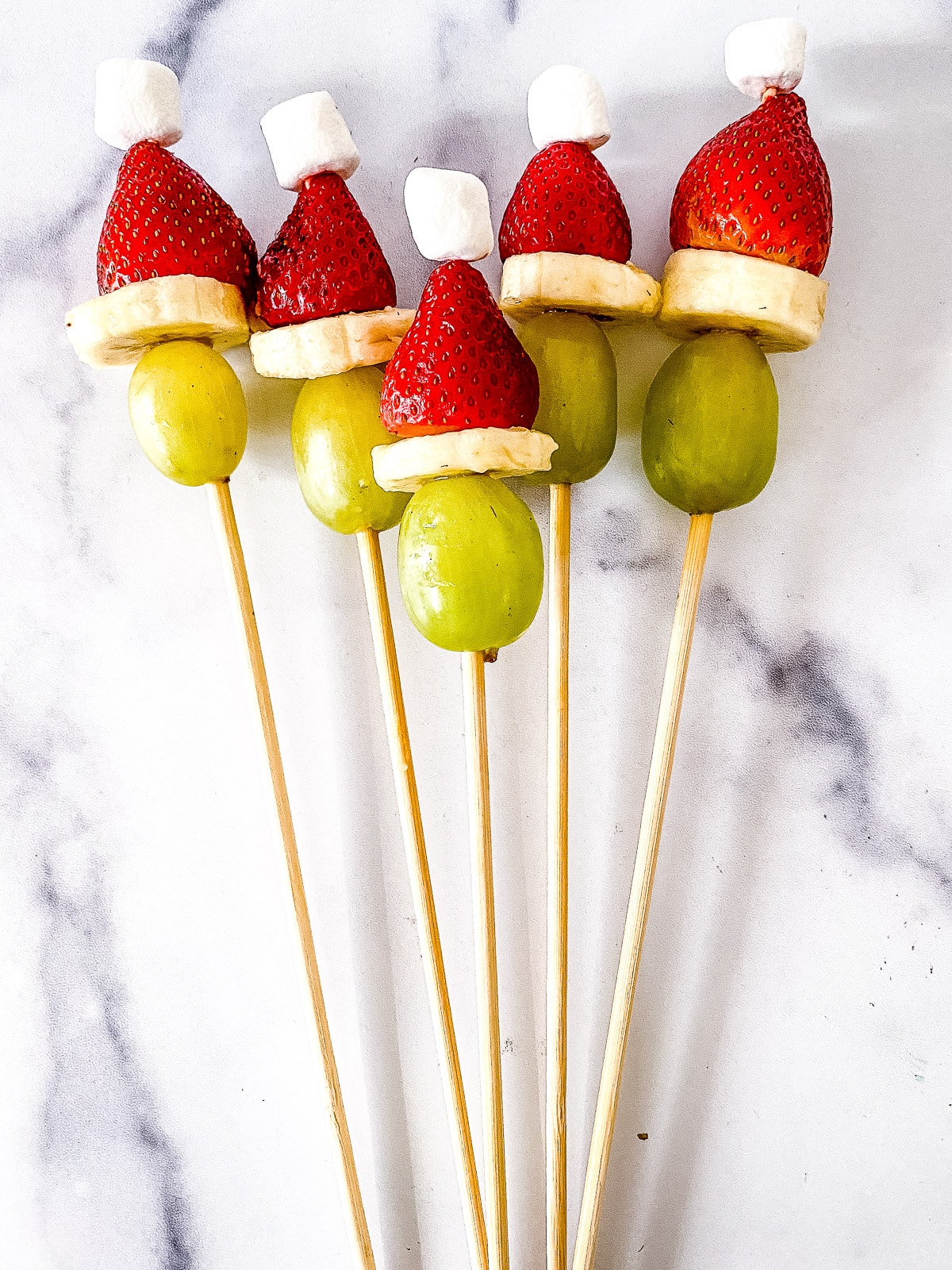 Skewers threaded with grapes, bananas, strawberries and marshmallows