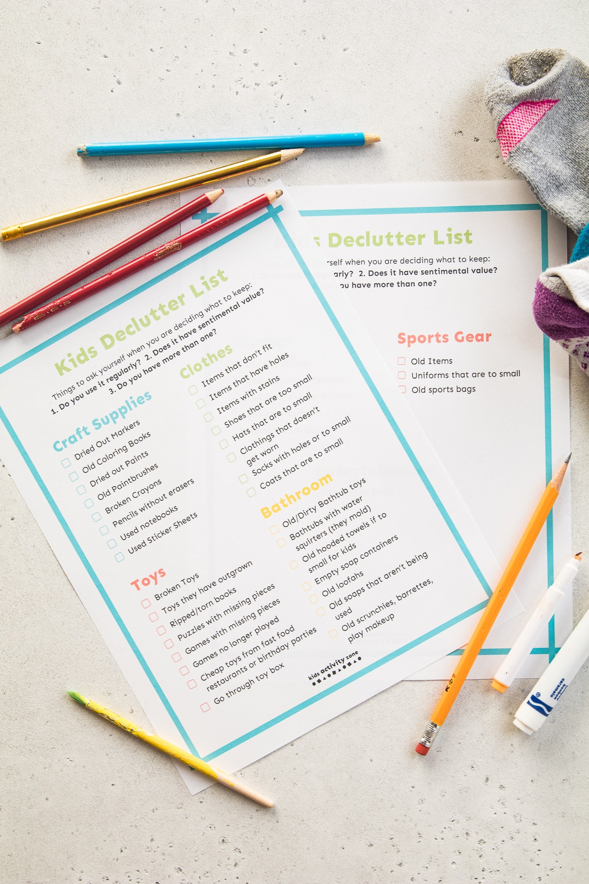 Kids Declutter Checklist on light background with old markers, pencils and socks