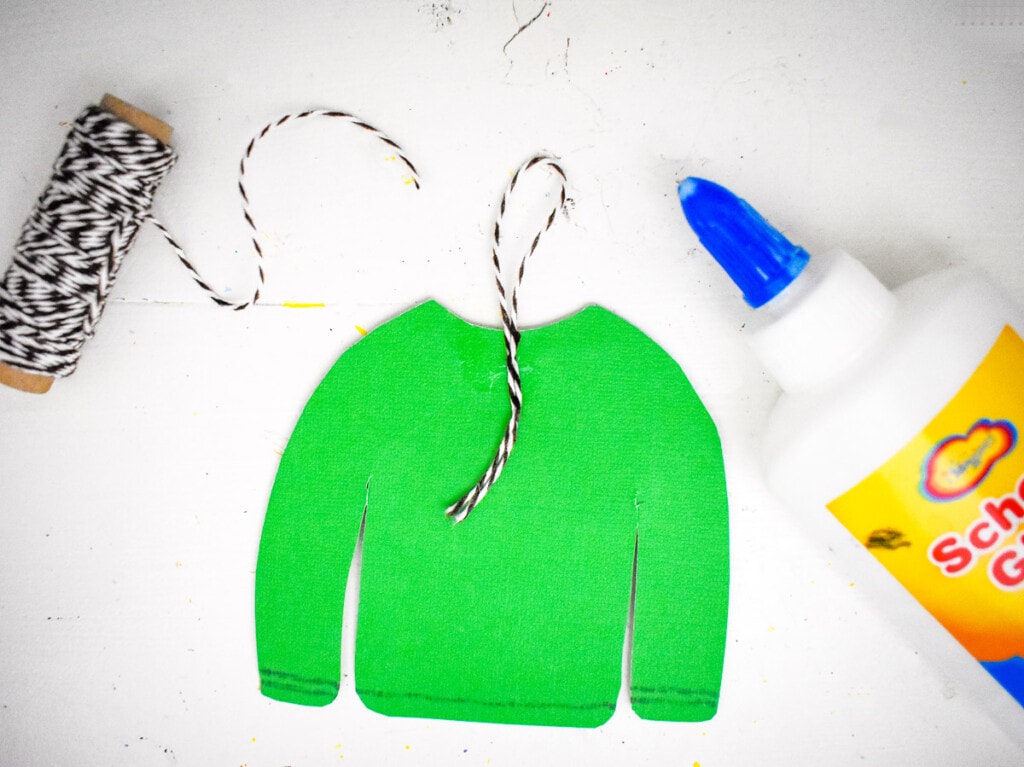 Putting string on ugly christmas sweater ornament