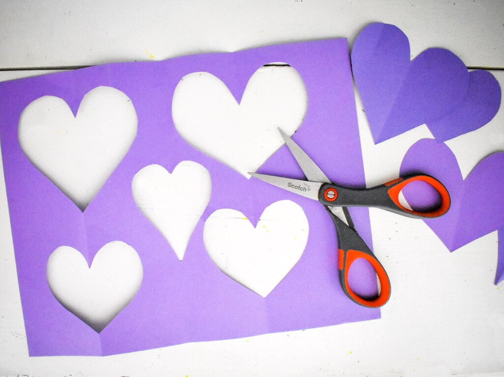 Purple paper with hearts cut out of it