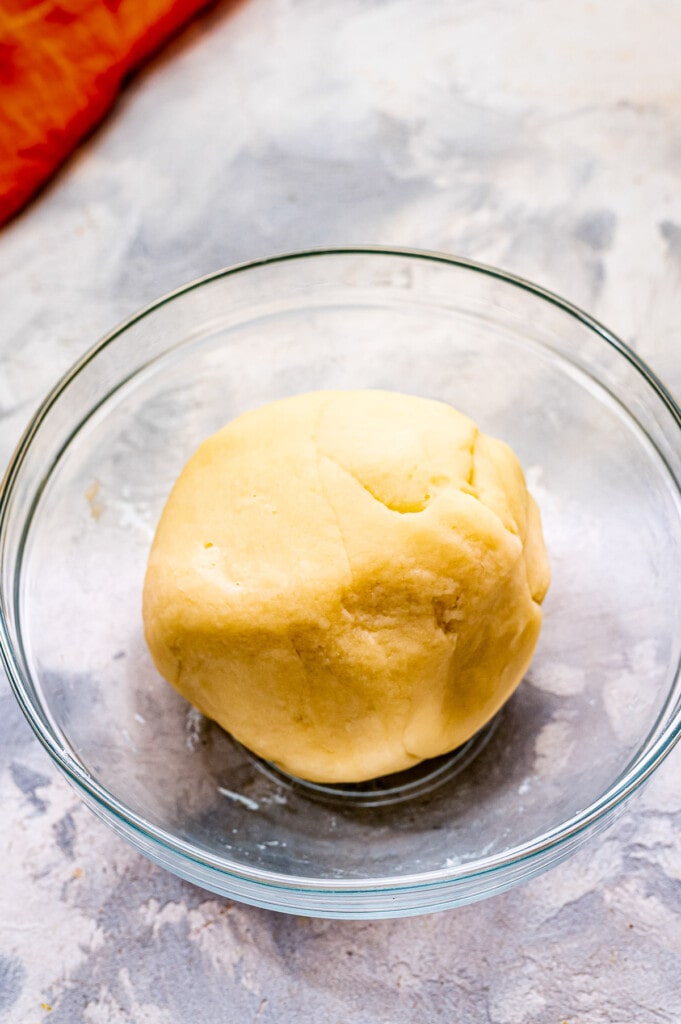 A ball of homemade playdough in glass bowl