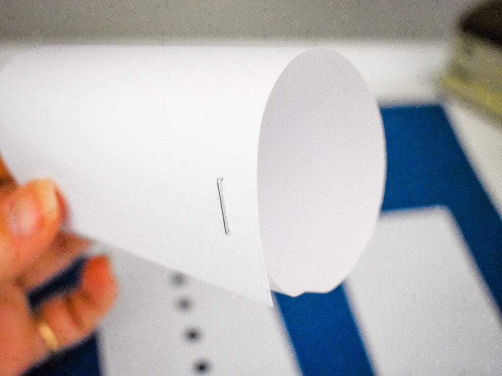 Stapling a strip of white paper in a loop