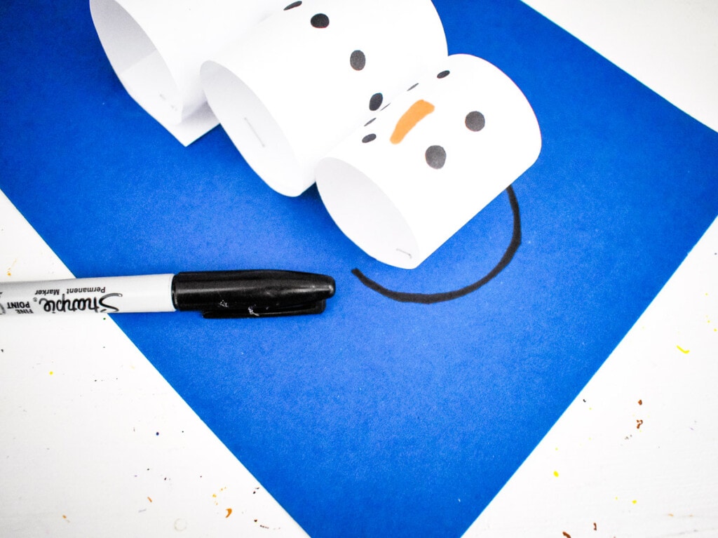 Drawing ear muff band on snowman