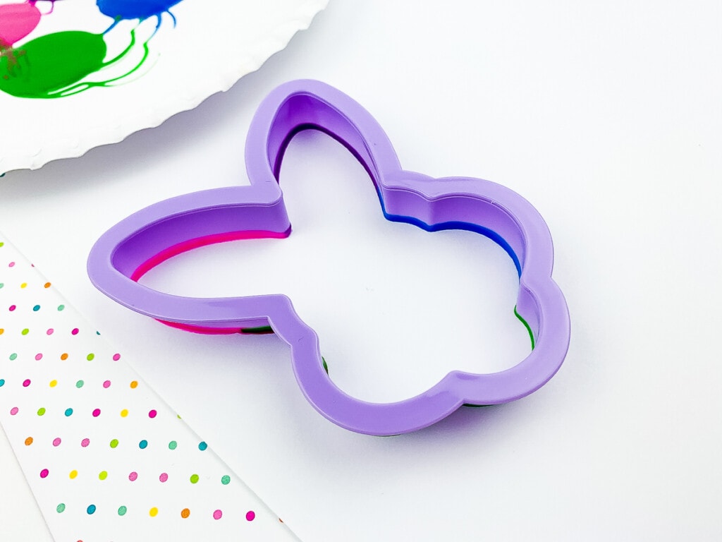 Cookie cutter dipped in paint laying on white paper
