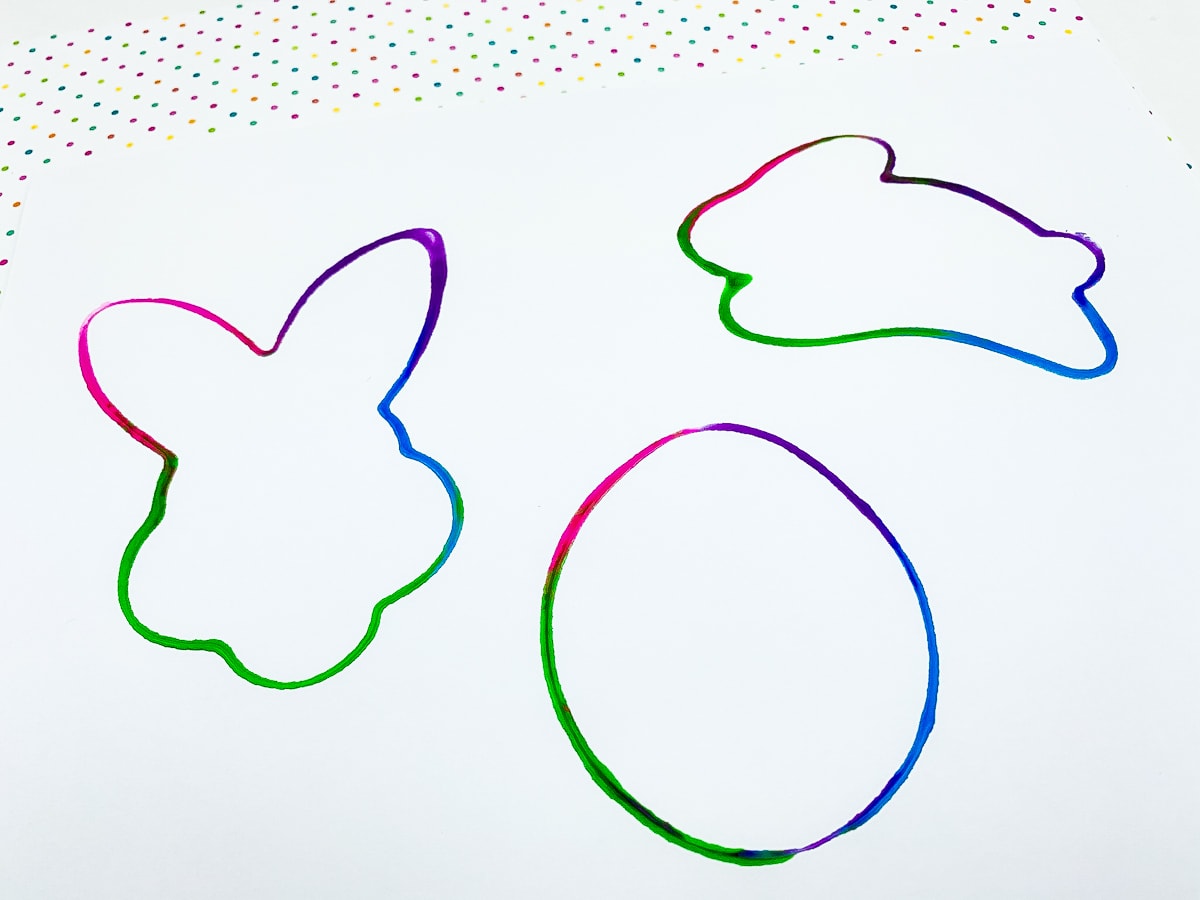 Colorful outlines of Easter images from cookie cutters dipped in paint