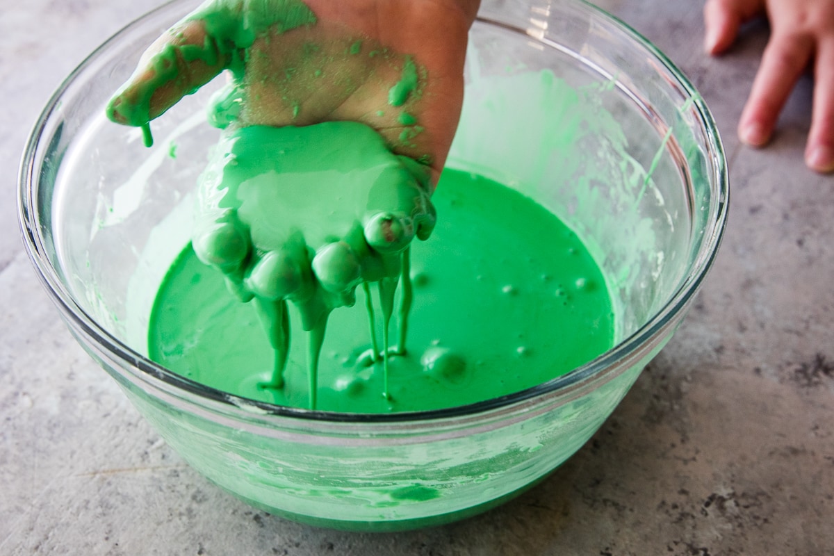 Kids hand with green oobleck on it