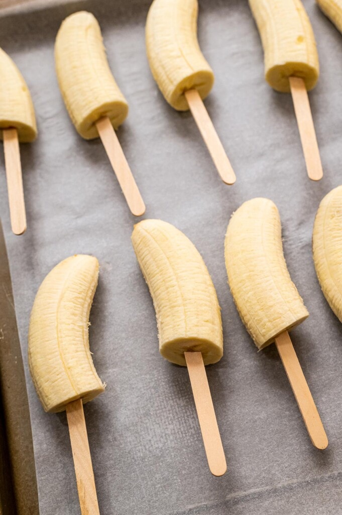 Half of bananas with popsicle sticks in them