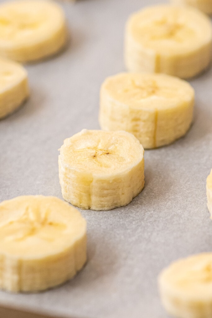Banana slices on parchment paper lined pan