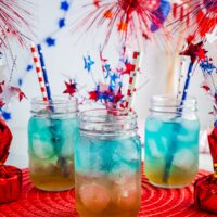 Red White and Blue Punch in three mason jars with red, white and blue decor