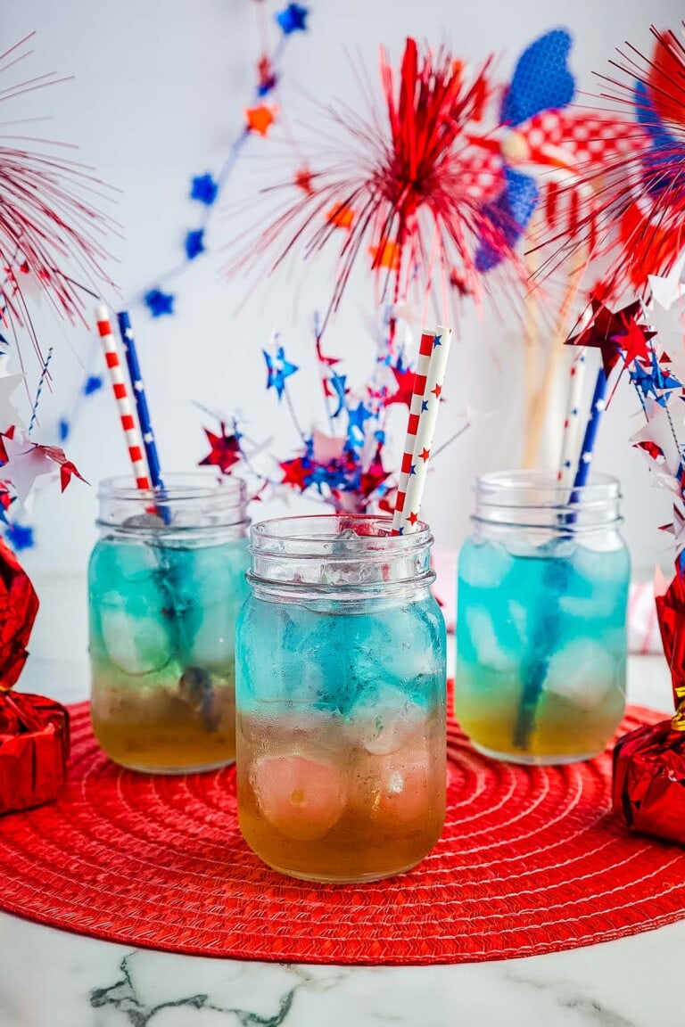 Red White and Blue Punch in three mason jars with red, white and blue decor