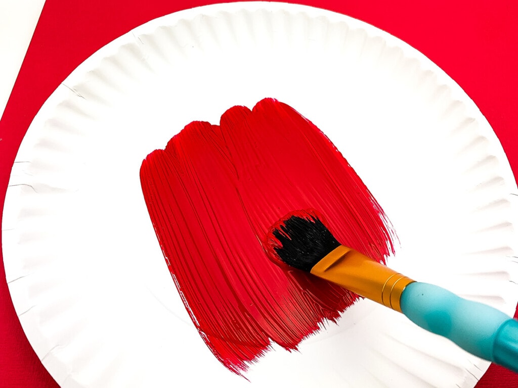 White paper plate being painted red