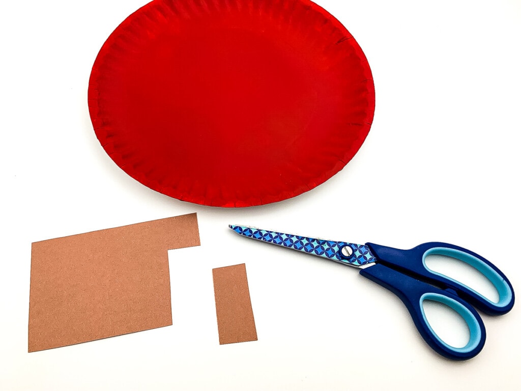 Scissors with brown paper and red paper plate