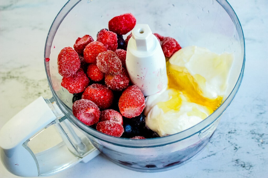 Food processor with ingredients for berry popsicles