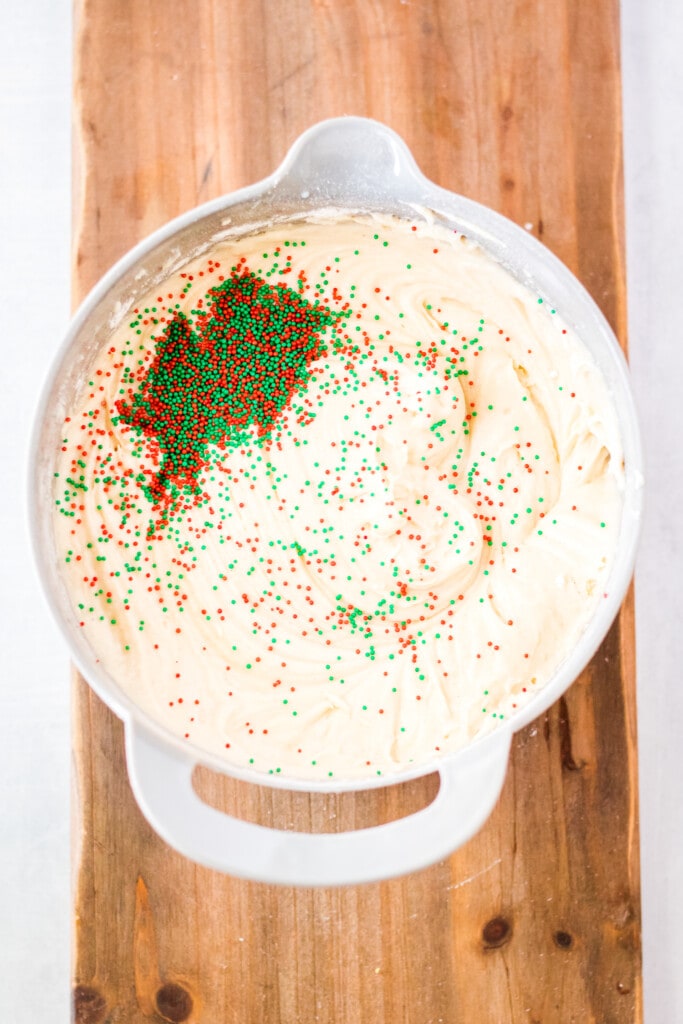 Overhead image of cupcake batter with red and green sprinkles