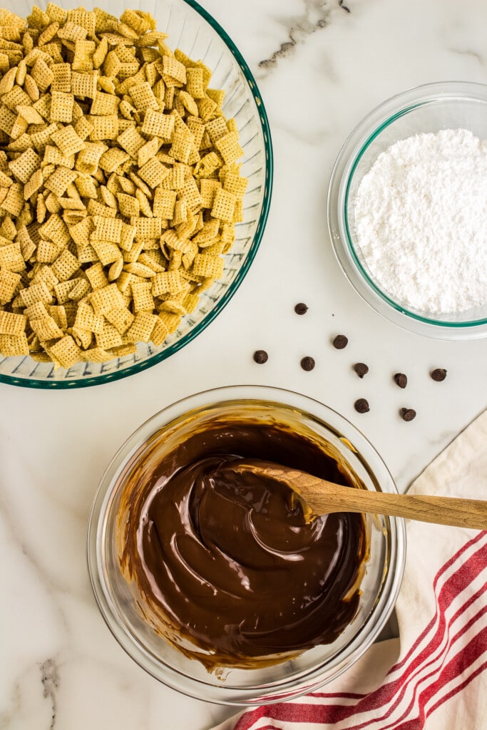 Overhead image of a glass bowl with melted chocolate and another bowl of chex cereal