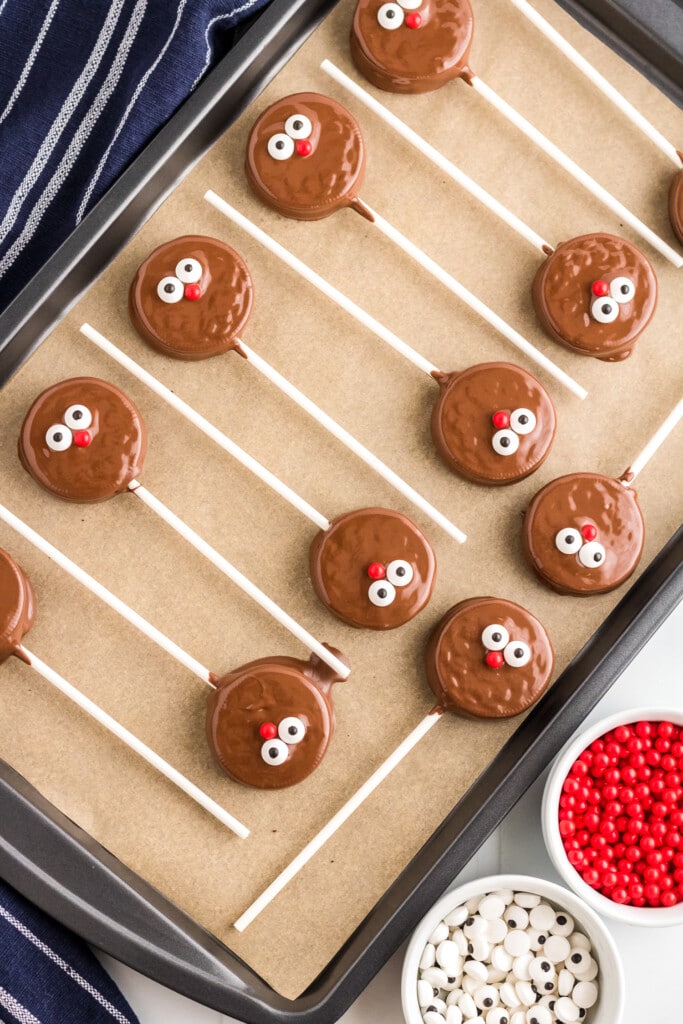 Reindeer Oreo Pops laying on parchment paper on baking sheet