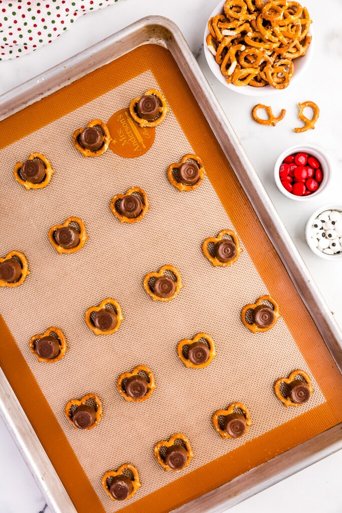 Overhead image of baking sheet with pretzels and a rolo on top of htem