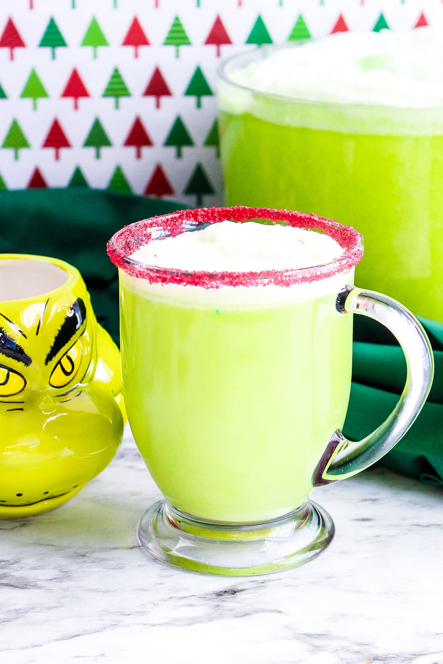 Mug of Grinch Punch with red sugar sand on rim of cup
