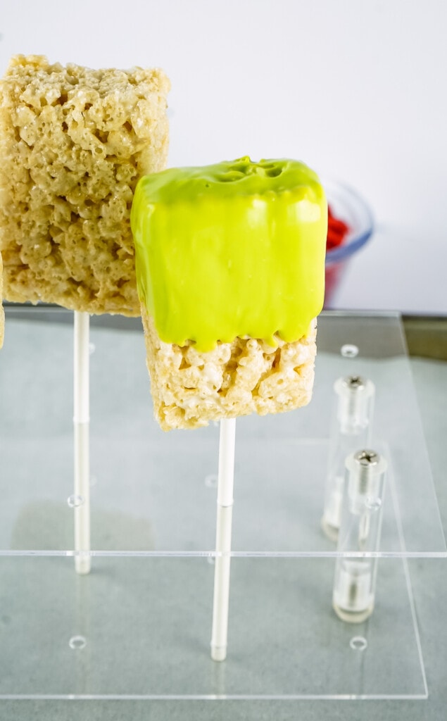 Green Candy Melt Dipped Rice Krispies in lollipop stand