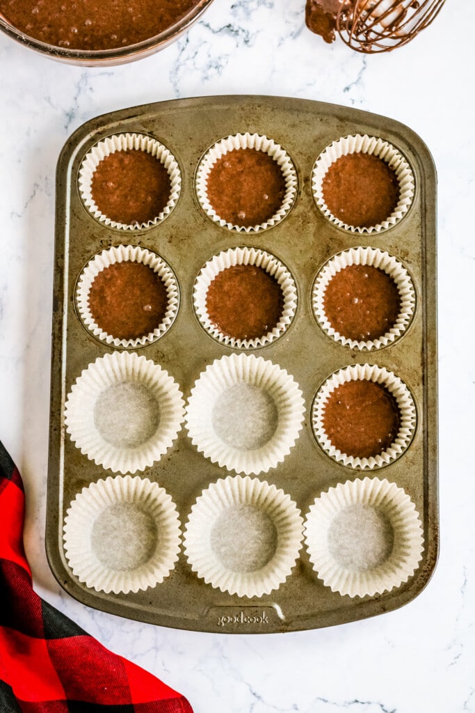 Muffin pan filled with with liners and chocolate cake mix