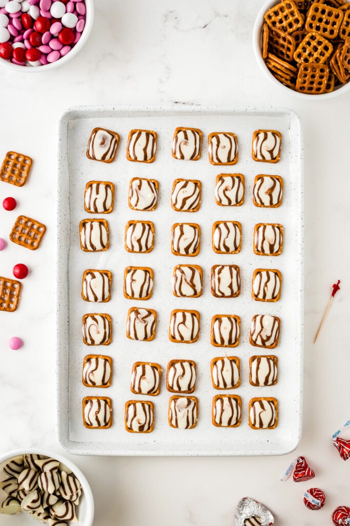 Overhead image of pan with square pretzel and melted hugs on top