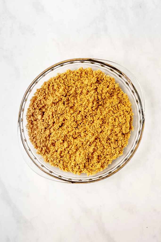 Crushed Golden Oreos with butter in pie plate