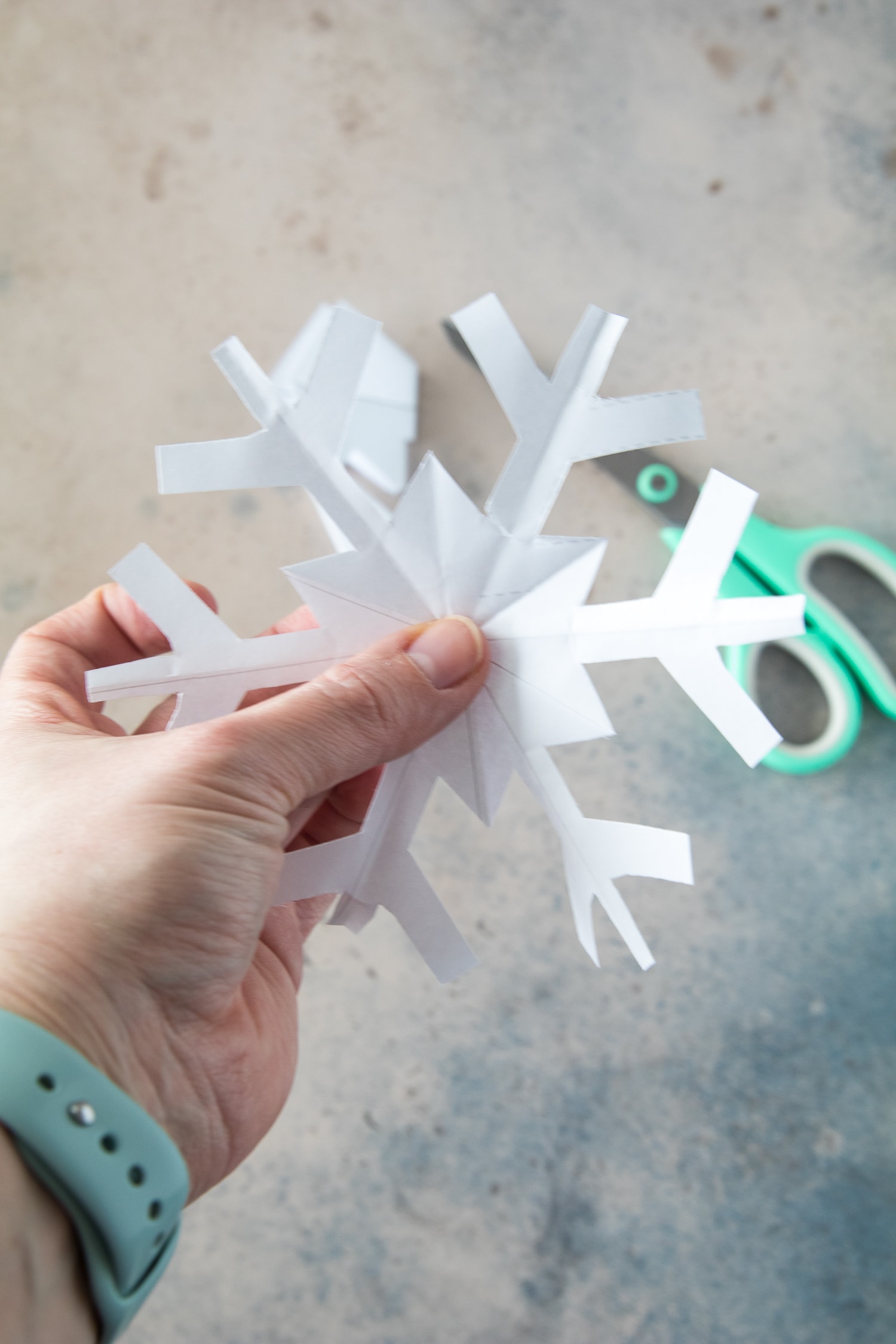 Hand holding paper snowflake