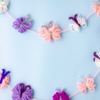 Yarn butterflies on a string on blue background