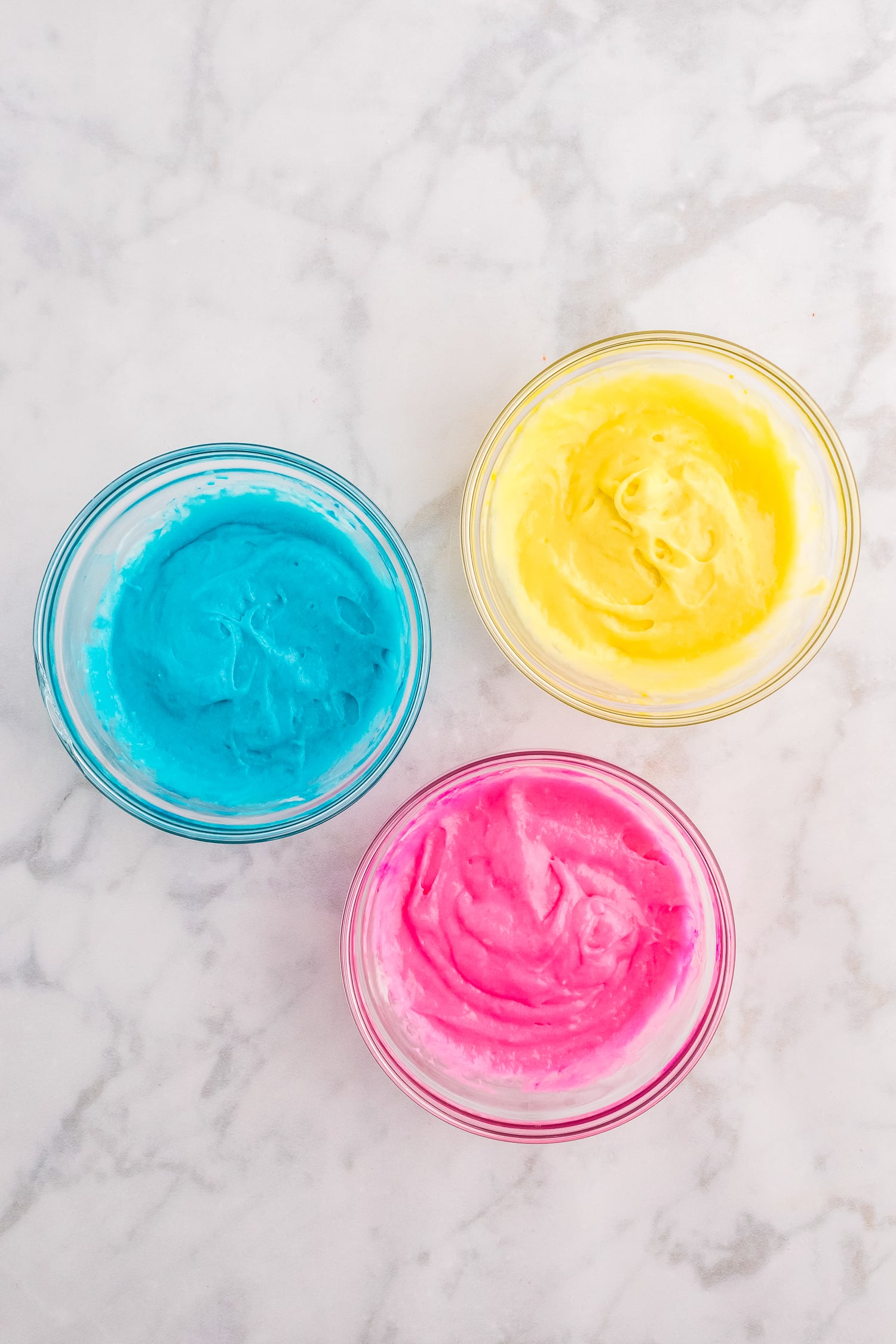 Pastel colored cake batter in mixing bowl