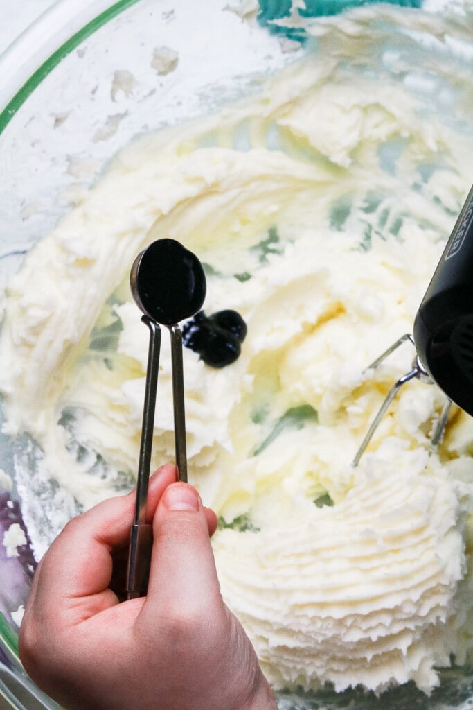 Putting blue food coloring into buttercream frosting