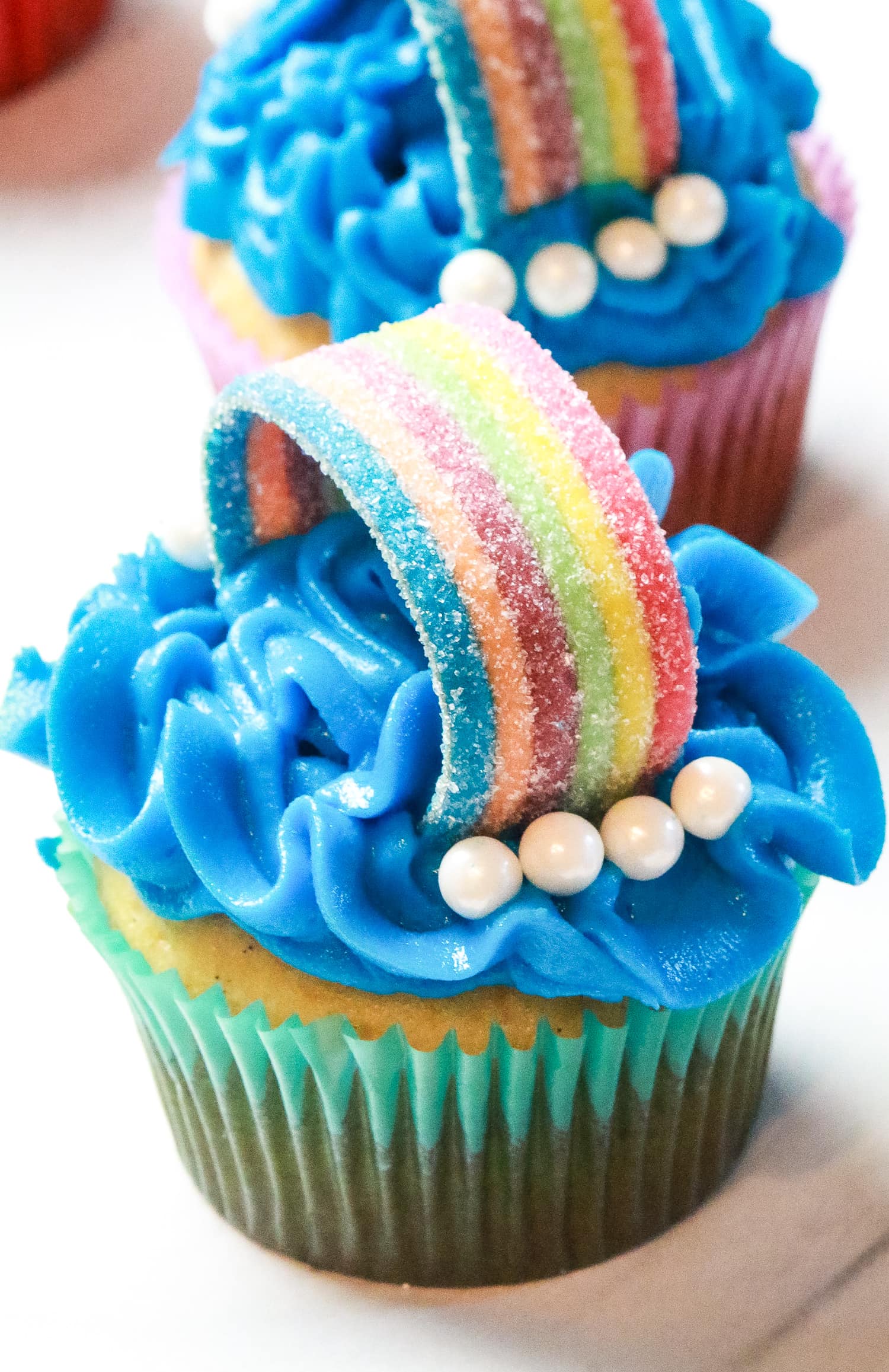 Cupcake decorated with blue frosting and rainbow candy
