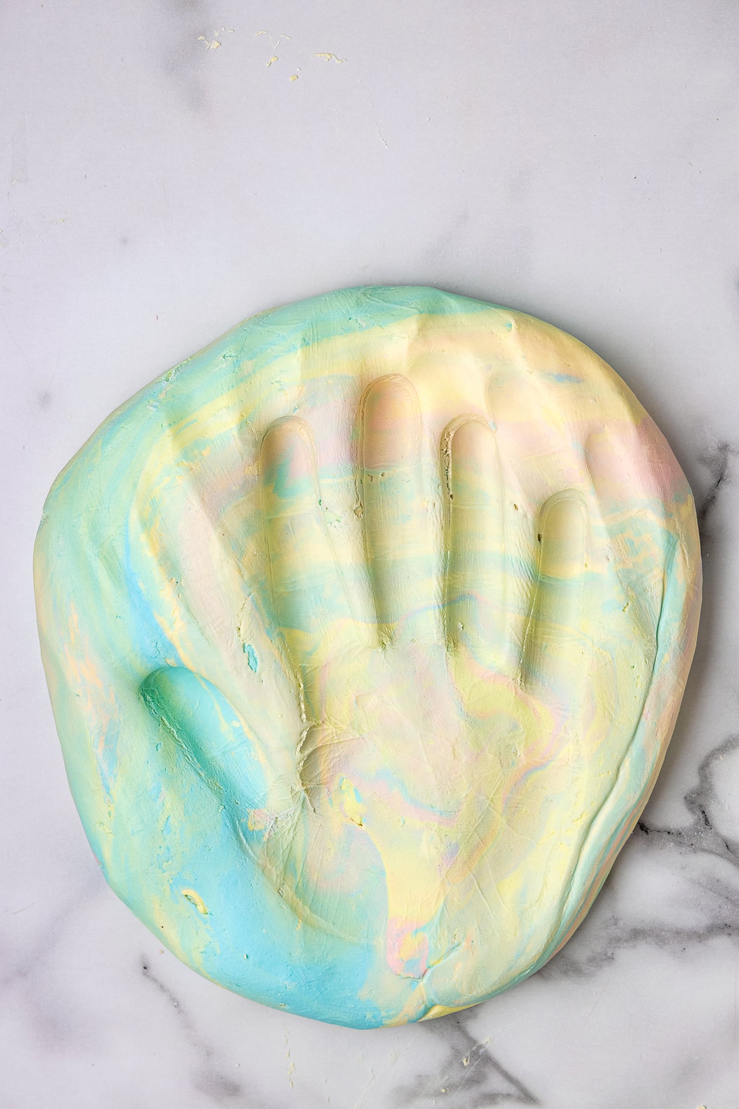 Hand print in colored cloud dough