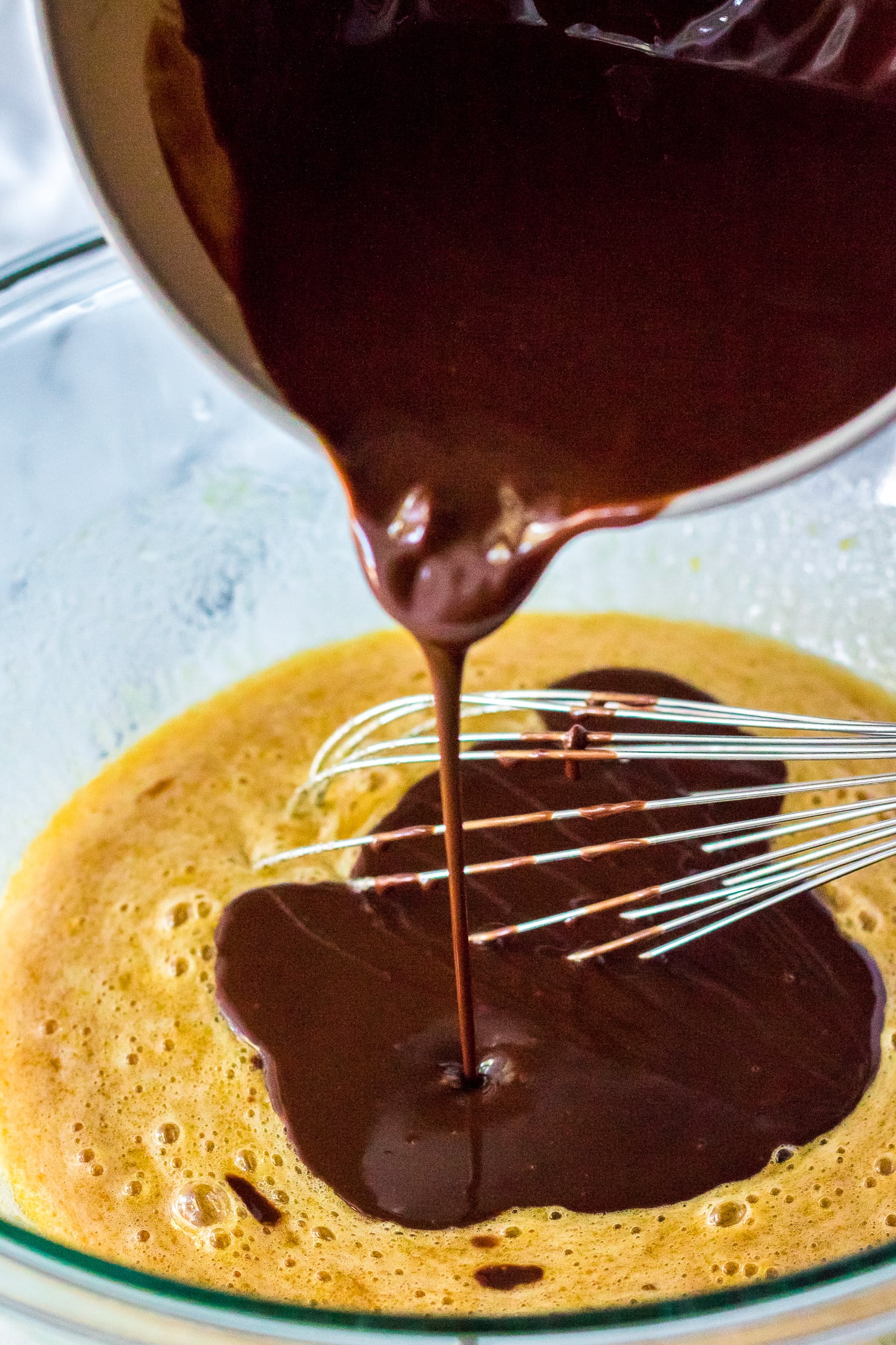 Pouring melted chocolate into brownie batter