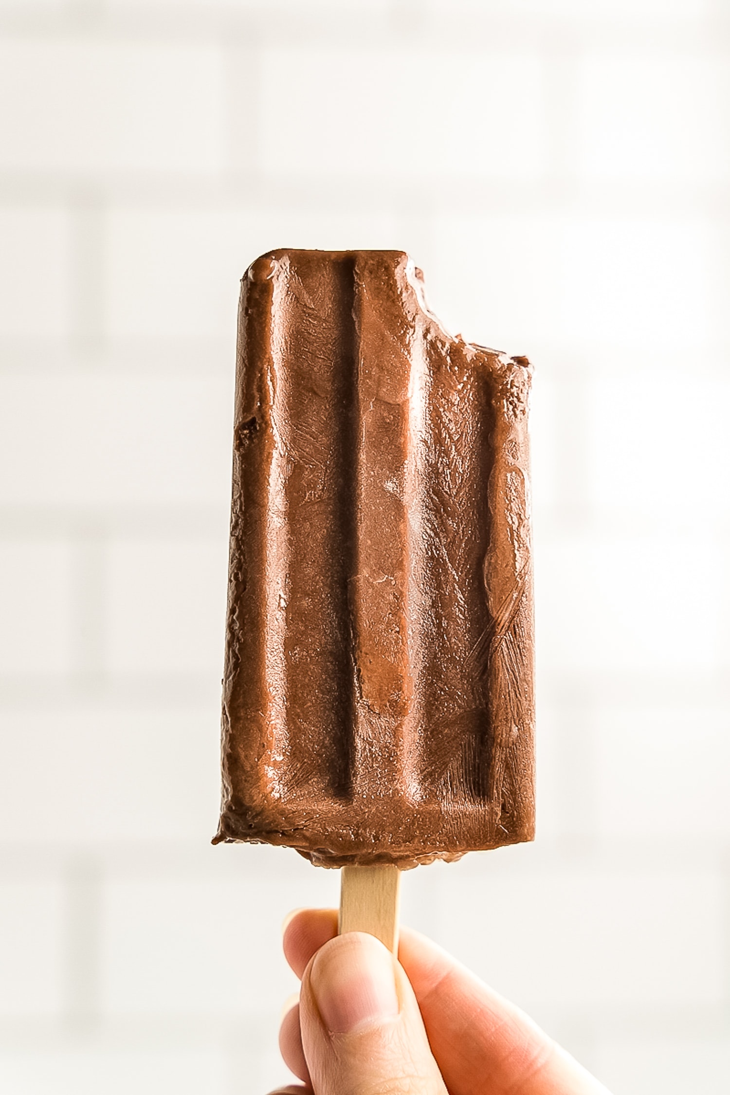 Hand holding fudgesicle with bite gone