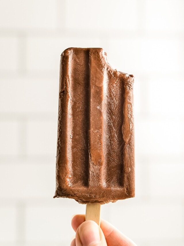 Hand holding fudgesicle with bite gone