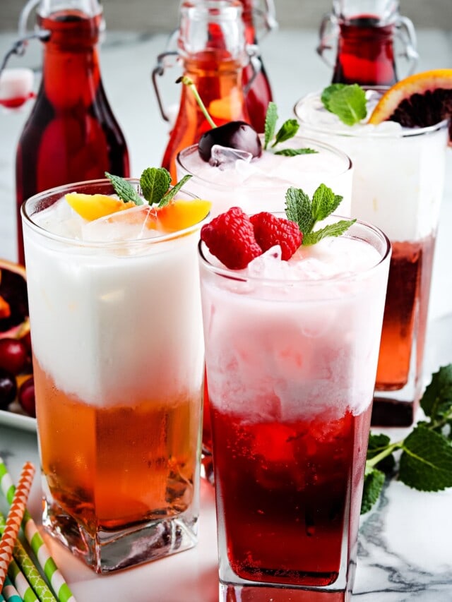 Three glasses of Italian Soda and garnishes.