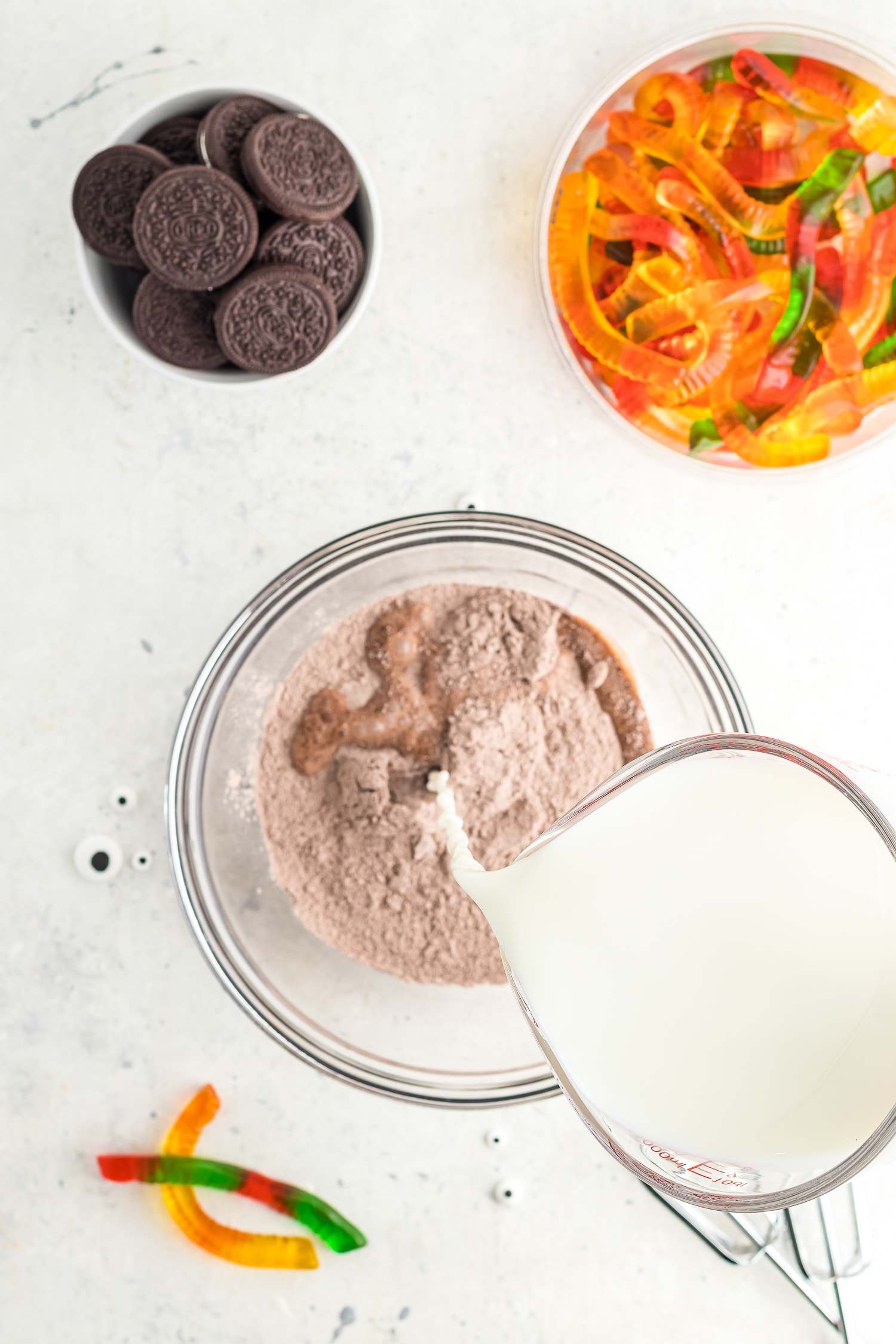 Adding milk to chocolate instant pudding mix in glass bowl