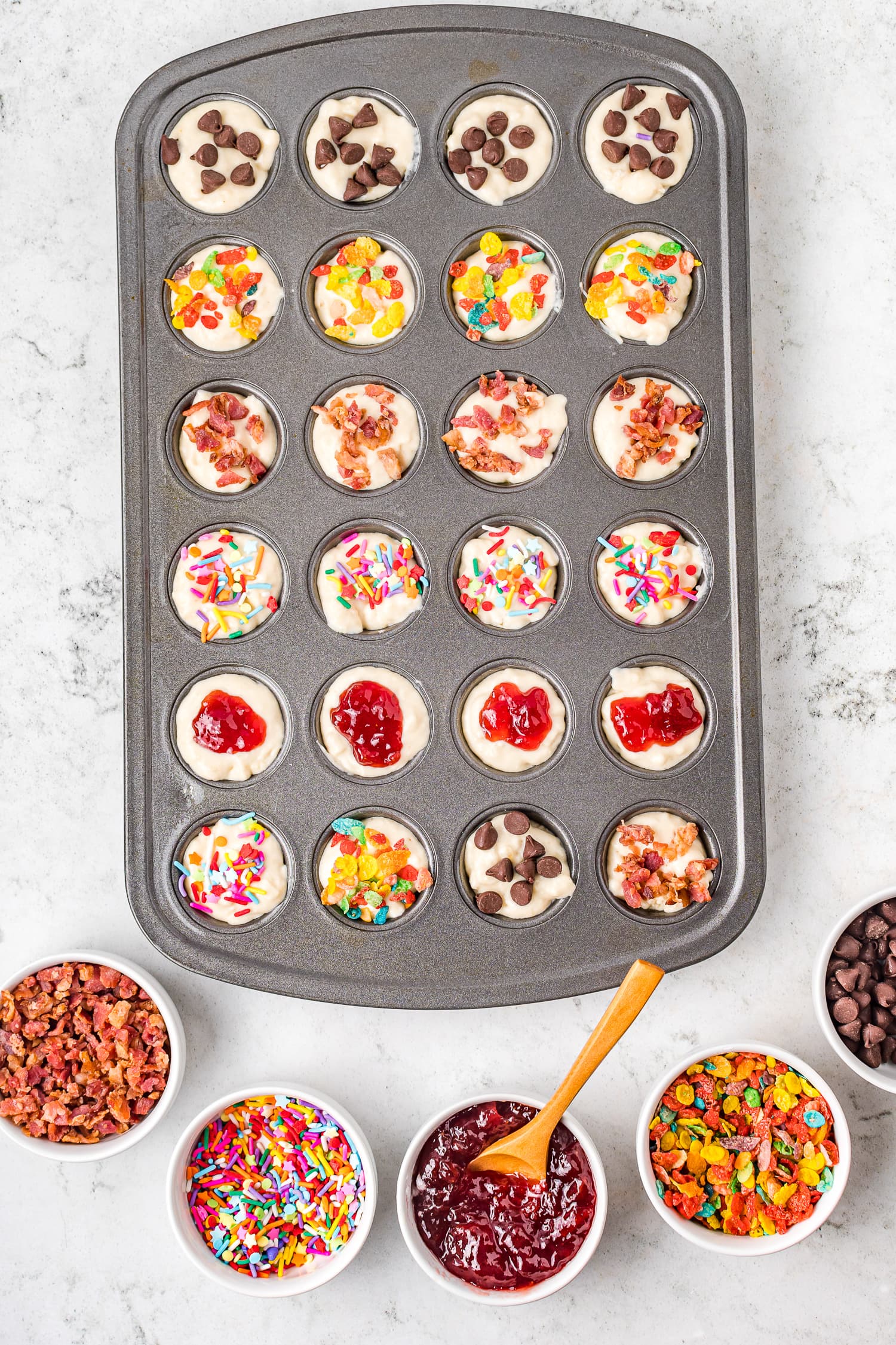 Mini muffin tin with pancake batter and toppings