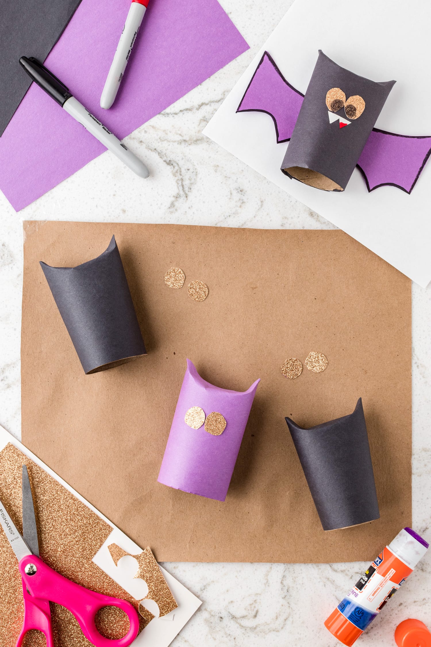 Putting eyes on bat craft made of paper towel roll