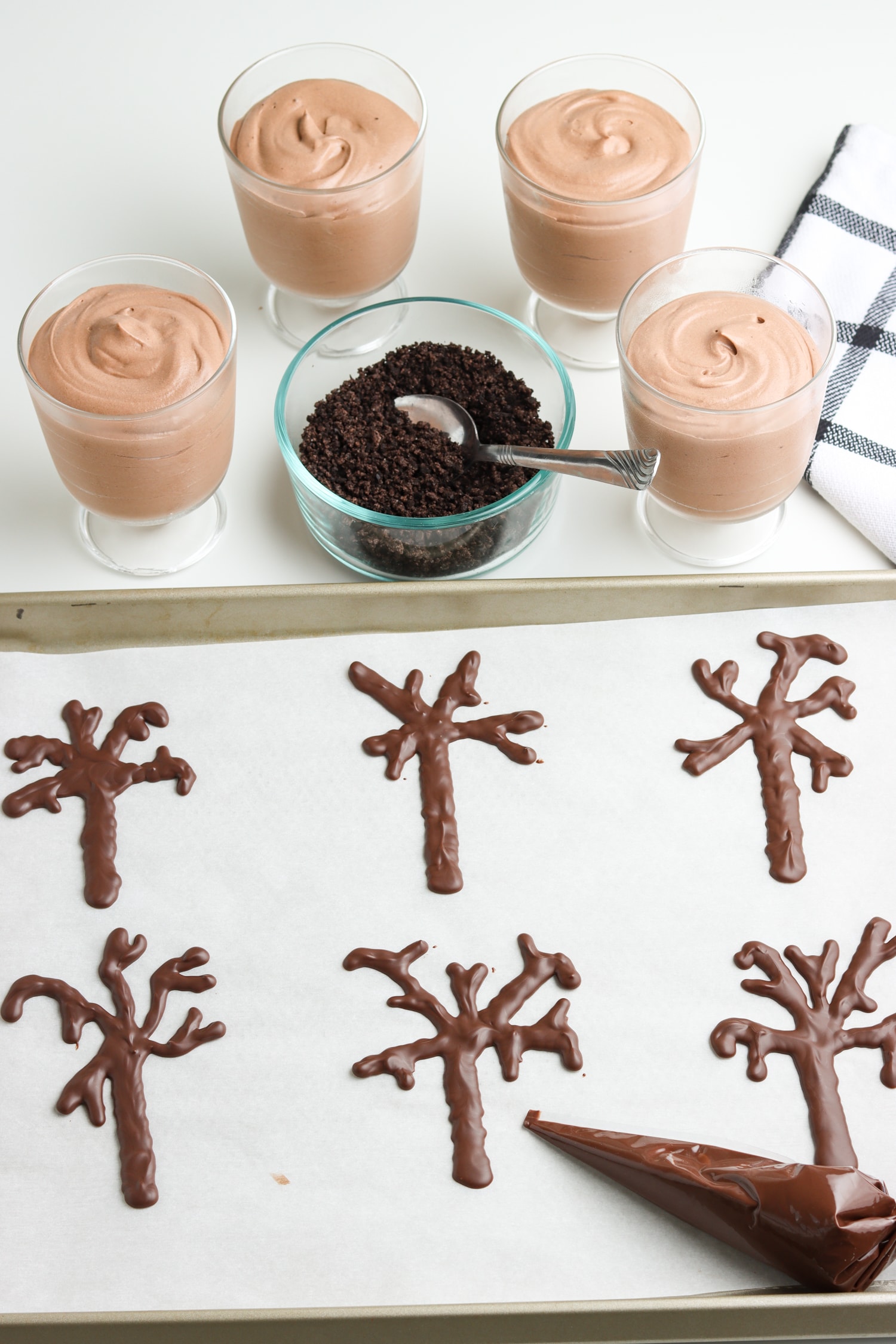 Chocolate trees piped on parchment paper