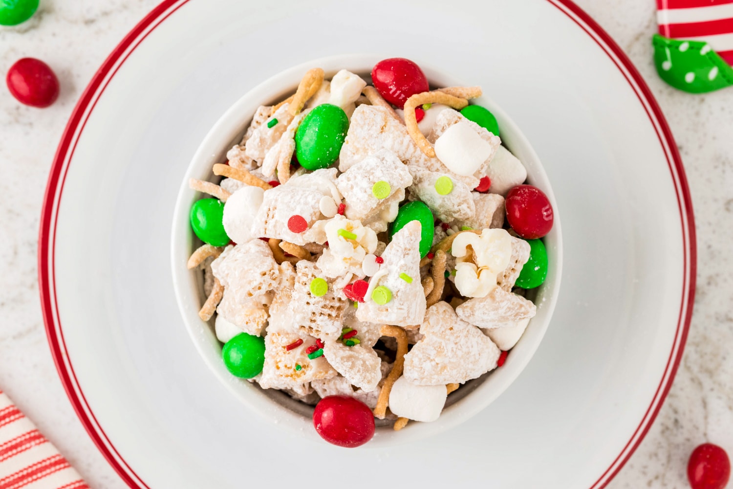 Overhead image of Christmas snack mix in white bowl