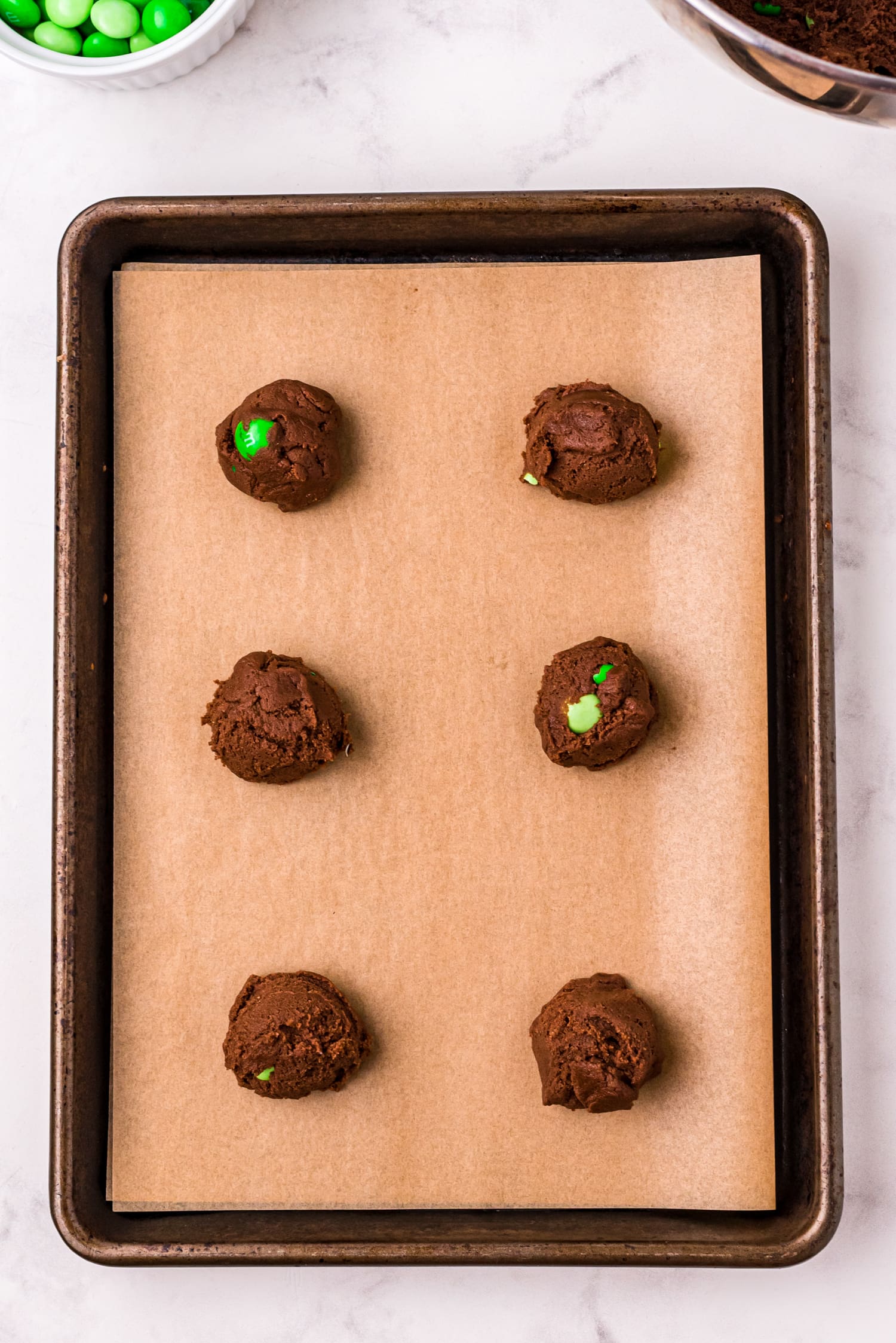 Baking sheet with chocolate cookie dough with mint M&Ms
