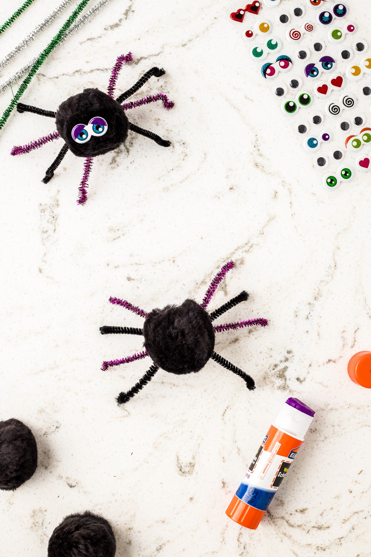Black pom pom with four pipe cleaner spider legs