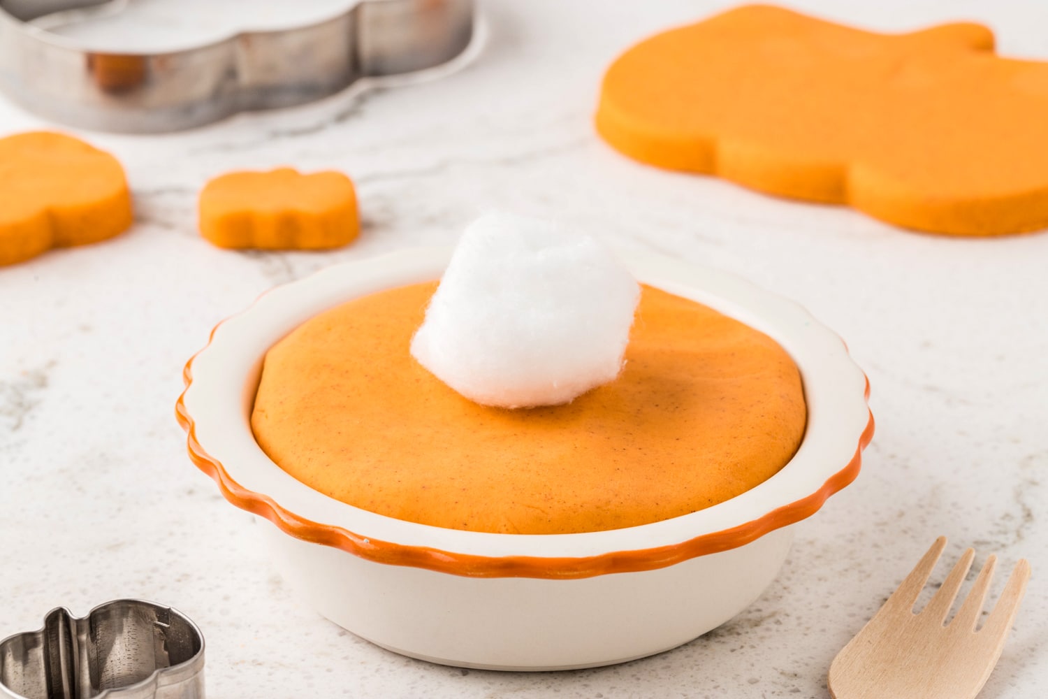 Small bowl with pumpkin spice playdough with cotton ball on top