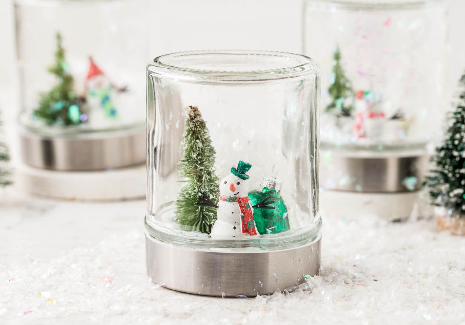 Snow Globe Completed and Displayed Standing Upright on top of Faux Snow