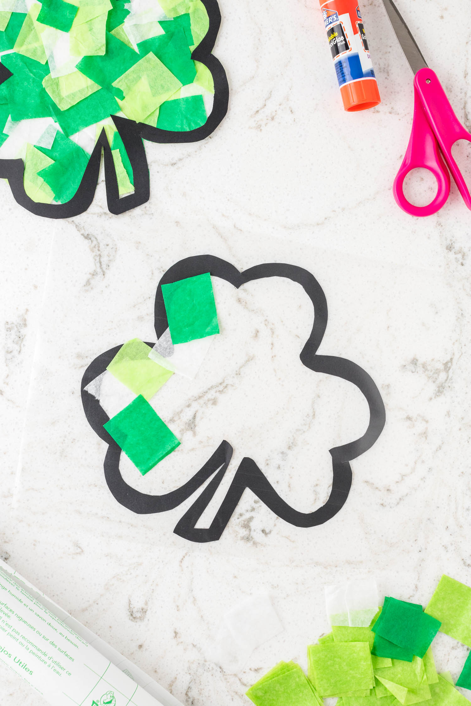 Cut a piece of clear contact paper and put on the back side of the already cut shamrock