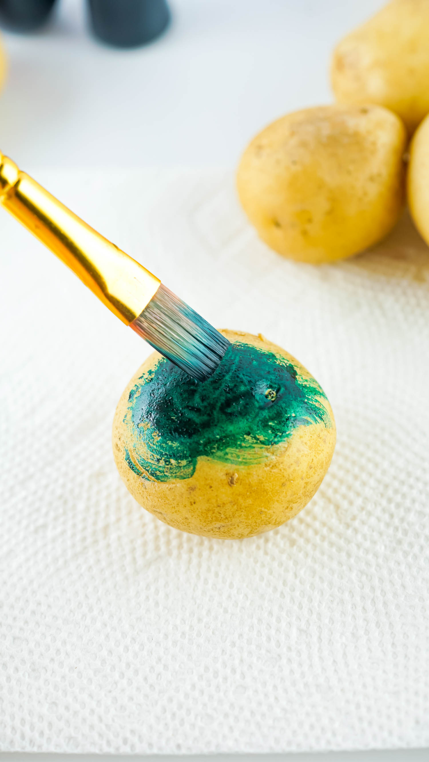 Use a Paint Brush to spread out the Food Coloring All over the Potato