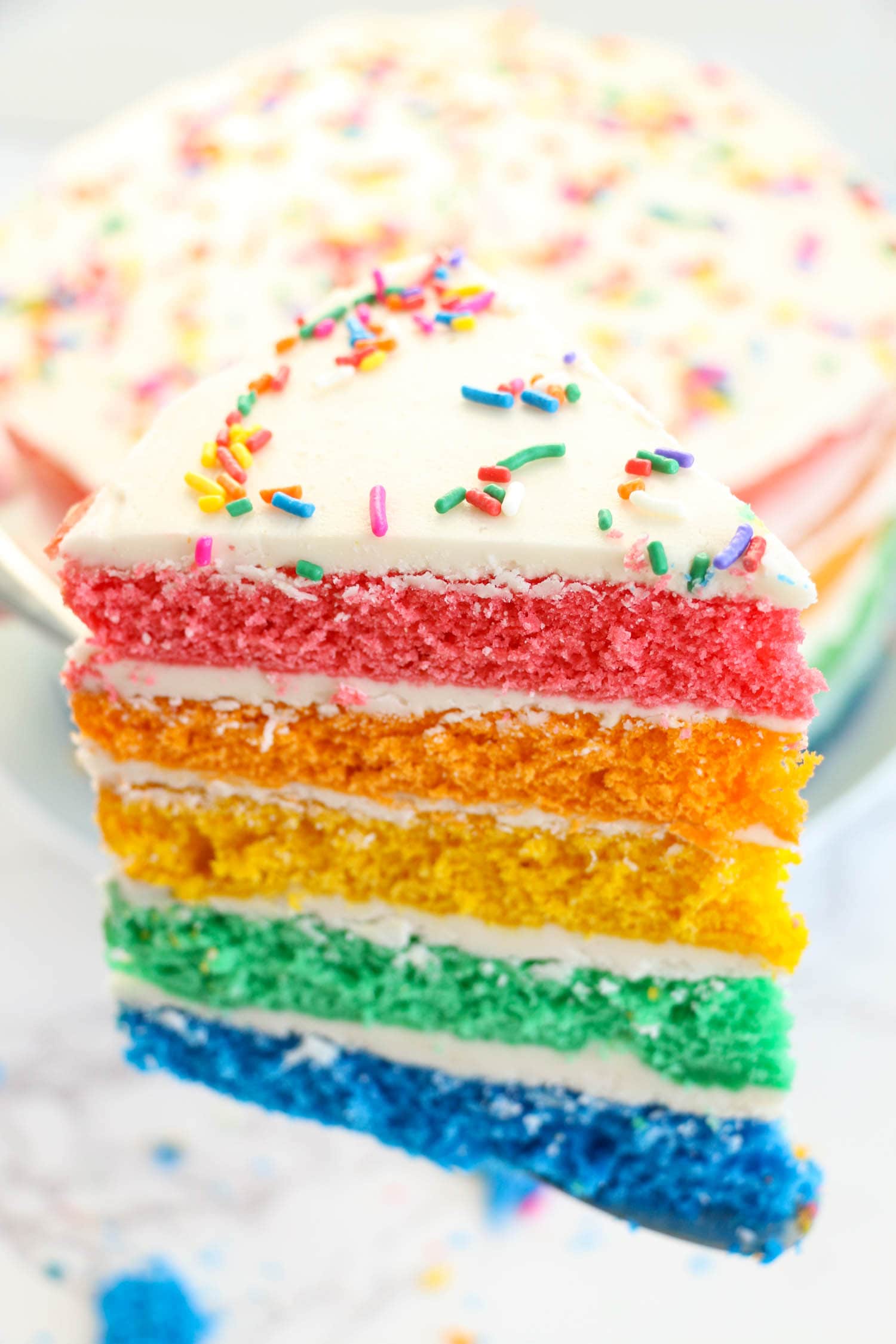 Showing a slice of the rainbow cake